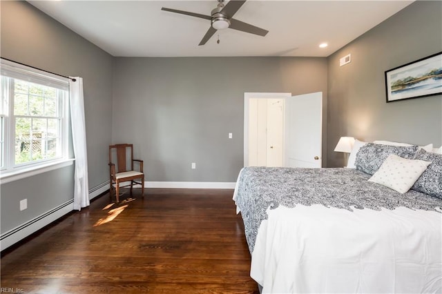 bedroom with dark wood-type flooring, visible vents, baseboards, and a baseboard heating unit
