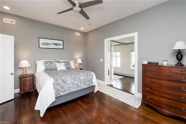 bedroom with hardwood / wood-style flooring, visible vents, and a baseboard radiator
