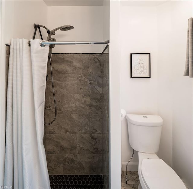 bathroom featuring toilet and a shower stall