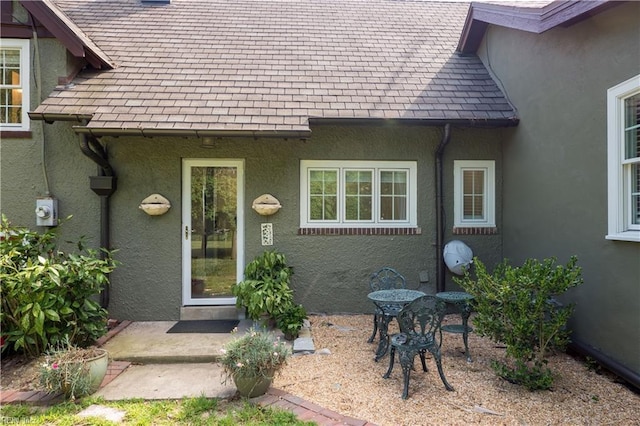 entrance to property featuring a patio area and stucco siding