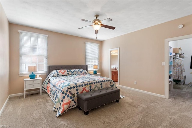 bedroom with ensuite bath, baseboards, carpet flooring, and ceiling fan