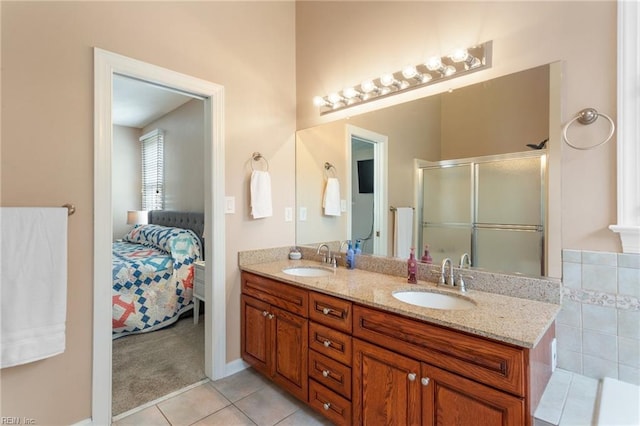 ensuite bathroom with tile patterned flooring, double vanity, a sink, and connected bathroom