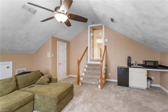 interior space featuring visible vents, light colored carpet, and a sink