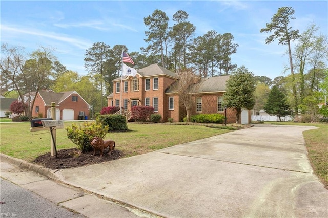 view of front of home featuring a front yard, brick siding, a garage, and driveway