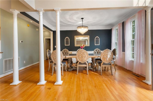 dining area featuring light wood finished floors, visible vents, and crown molding