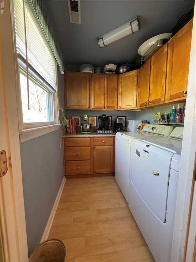 laundry area with baseboards, visible vents, independent washer and dryer, laundry area, and light wood finished floors
