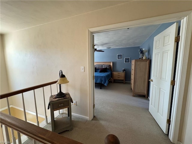 hall with baseboards and carpet floors