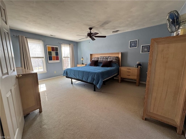 bedroom featuring light carpet, a ceiling fan, visible vents, and a textured ceiling