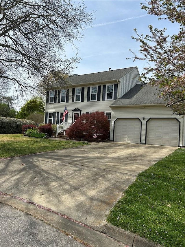 colonial-style house featuring a front lawn, a garage, and concrete driveway