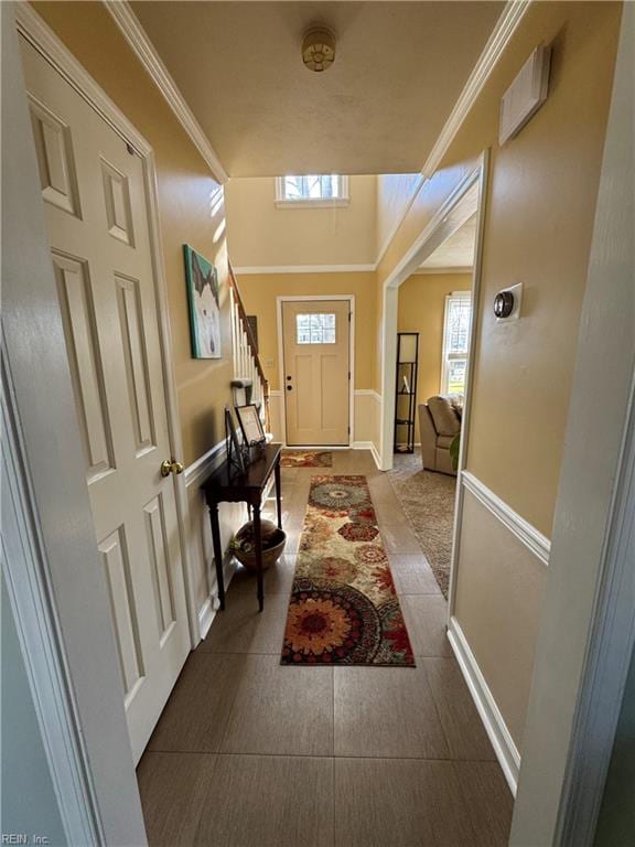 entryway with stairway, baseboards, and ornamental molding