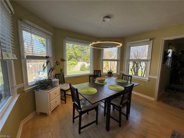 dining area featuring light wood-style flooring and baseboards