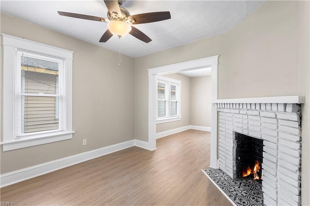 2916 Somme Ave, Norfolk, VA 23509 - unfurnished living room featuring light wood-style floors, a brick fireplace, baseboards, and a ceiling fan
