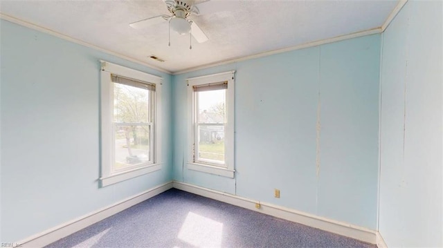 unfurnished room featuring crown molding, baseboards, ceiling fan, and visible vents