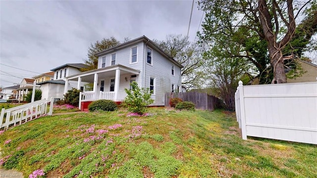 exterior space with a yard, fence, and covered porch
