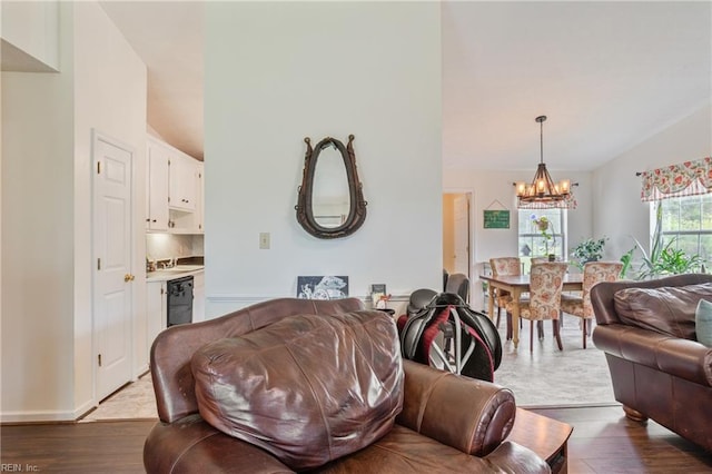 living area featuring a notable chandelier, wood finished floors, and lofted ceiling