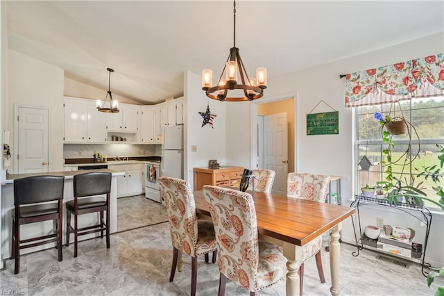 dining space featuring a notable chandelier and lofted ceiling
