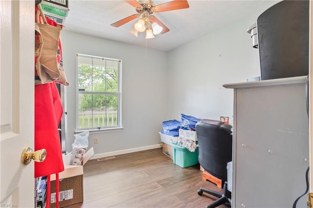 office area featuring ceiling fan, baseboards, visible vents, and wood finished floors