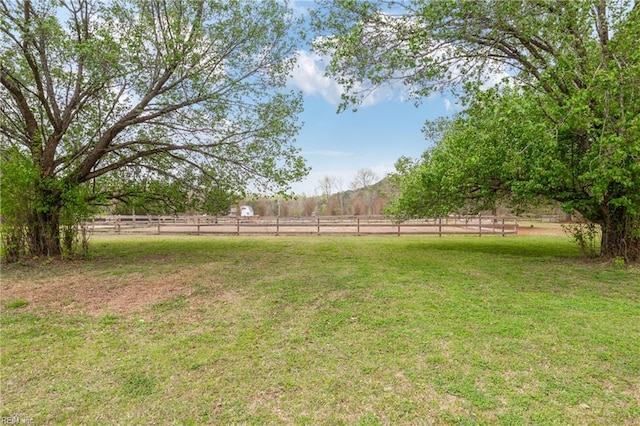 view of yard with a rural view and fence