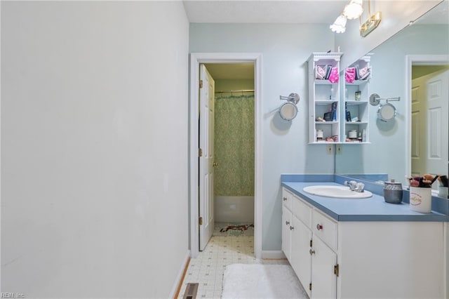 full bath with curtained shower, vanity, baseboards, and tile patterned floors