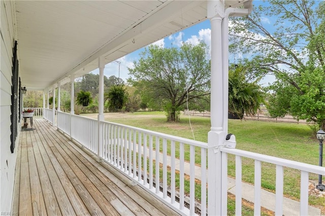 wooden terrace featuring a yard and covered porch