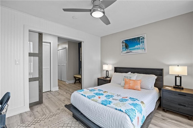 bedroom featuring ceiling fan, a closet, baseboards, and wood finished floors