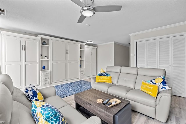 living area with crown molding, light wood finished floors, and a textured ceiling