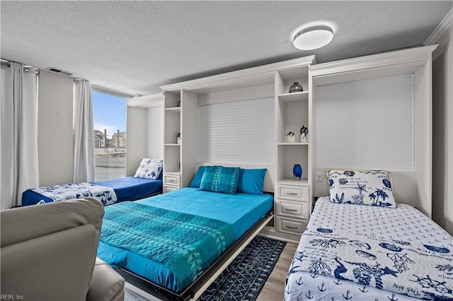 bedroom with light wood-style flooring and a textured ceiling
