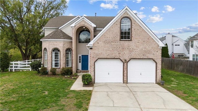 traditional-style home featuring a front yard, a garage, fence, concrete driveway, and brick siding