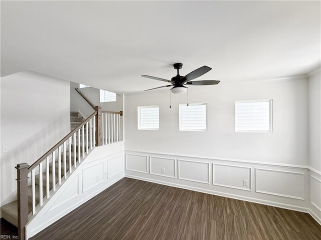 1539 Waltham Ln, Newport News, VA 23608 - spare room featuring stairs, ceiling fan, dark wood-style floors, a decorative wall, and a wainscoted wall