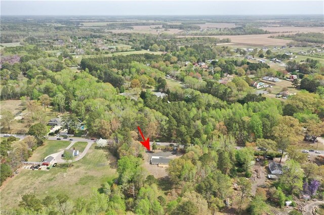 aerial view of property and surrounding area featuring a heavily wooded area