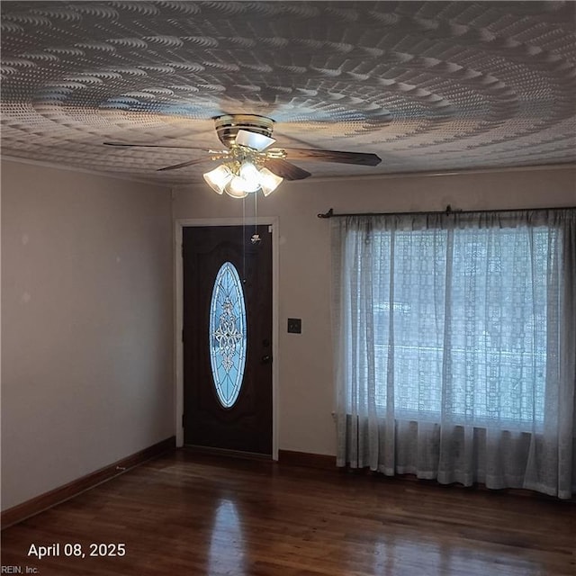 foyer entrance with ceiling fan, baseboards, and wood finished floors