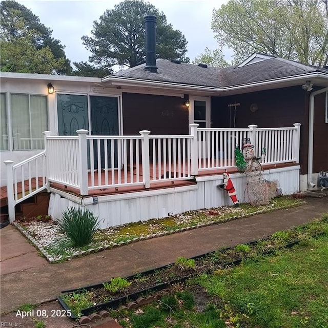 back of property with a shingled roof and covered porch