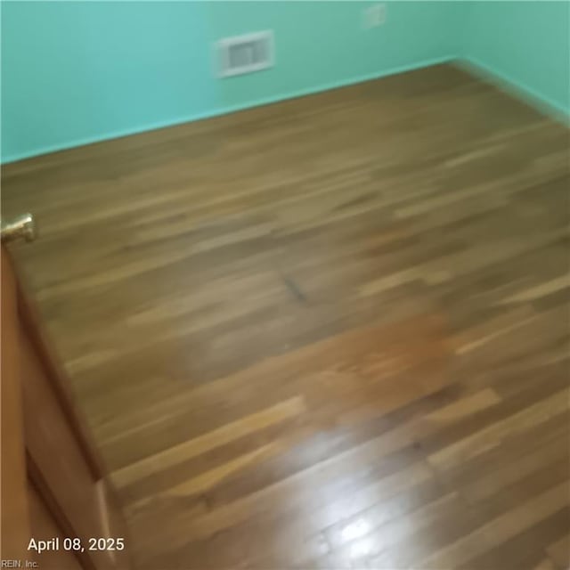 unfurnished room featuring wood finished floors and visible vents