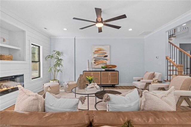 3545 Winston Ave, Virginia Beach, VA 23456 - living room featuring crown molding, a ceiling fan, a glass covered fireplace, stairway, and wood finished floors