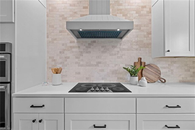 3545 Winston Ave, Virginia Beach, VA 23456 - kitchen featuring wall chimney range hood, light countertops, white cabinetry, black electric cooktop, and decorative backsplash