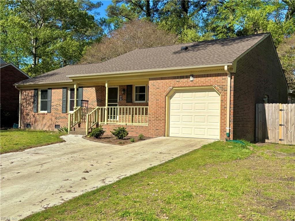 ranch-style house featuring concrete driveway, a front yard, brick siding, a garage, and covered porch