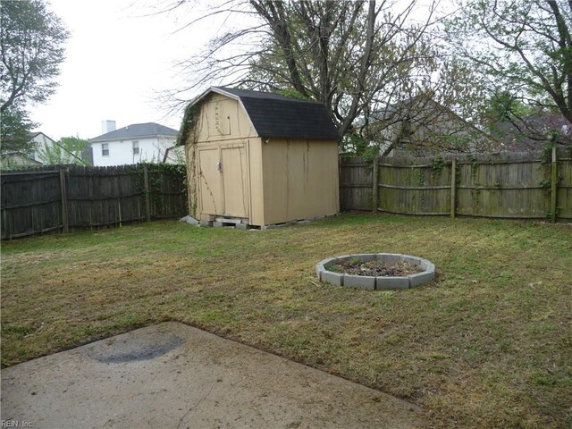 view of yard with an outbuilding, a storage unit, and a fenced backyard