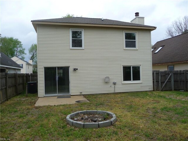 back of house with a yard, a fenced backyard, central AC unit, and a chimney