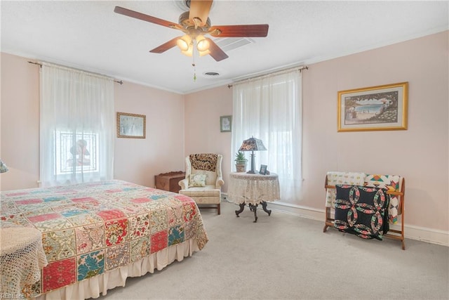 bedroom with visible vents, baseboards, ornamental molding, a ceiling fan, and carpet