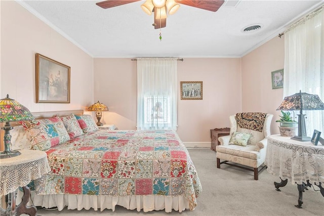 bedroom with crown molding, visible vents, a ceiling fan, and carpet