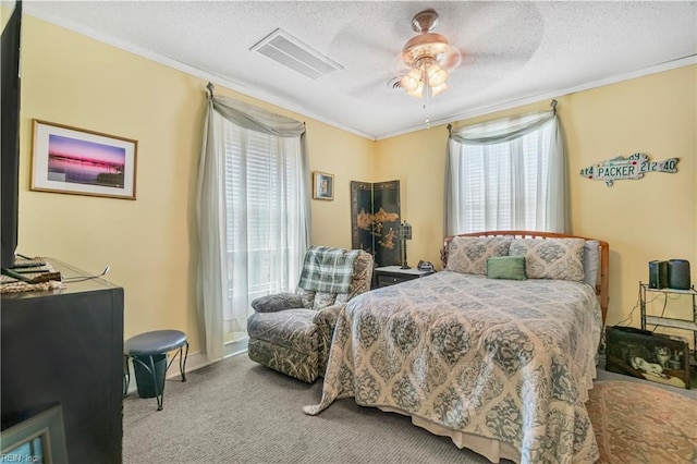 carpeted bedroom with crown molding, visible vents, and a textured ceiling