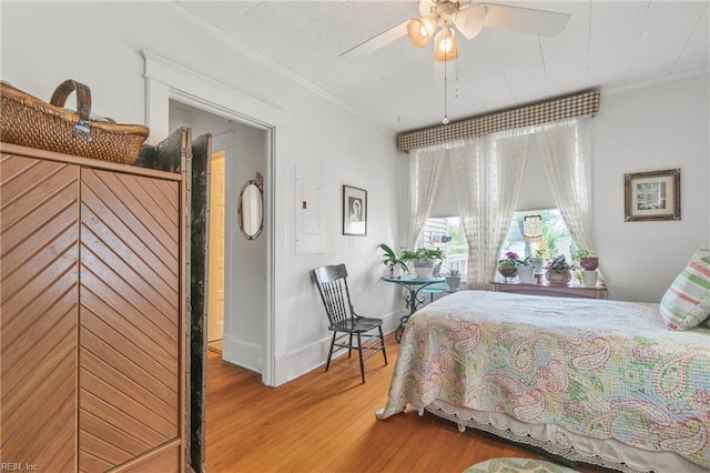 bedroom with crown molding, wood finished floors, baseboards, and a ceiling fan