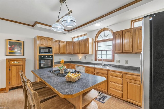 kitchen featuring a breakfast bar, dark countertops, black appliances, brown cabinets, and a sink