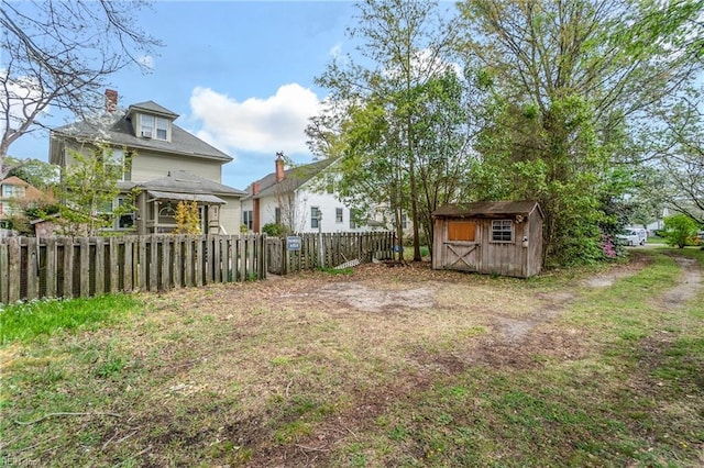 view of yard with a fenced backyard, an outdoor structure, and a shed