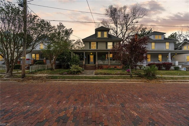 american foursquare style home with a porch
