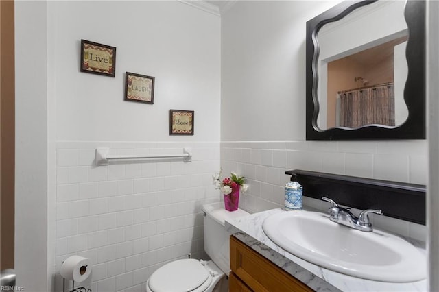 full bath with crown molding, vanity, a wainscoted wall, toilet, and tile walls