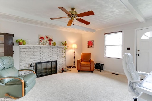 interior space with beamed ceiling, ceiling fan, visible vents, carpet flooring, and a brick fireplace