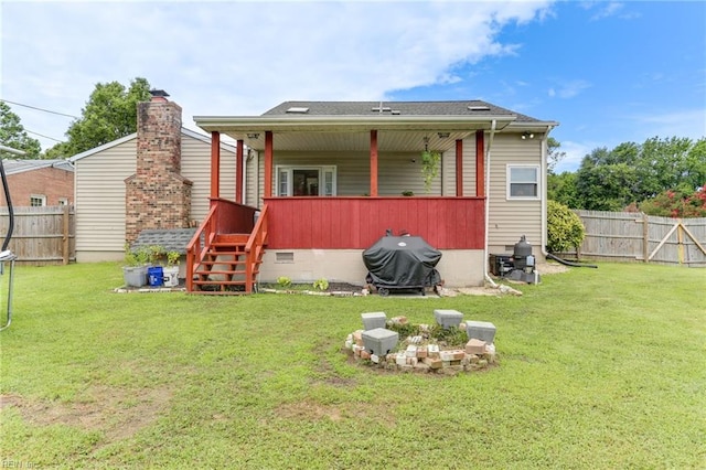 rear view of house with fence and a lawn