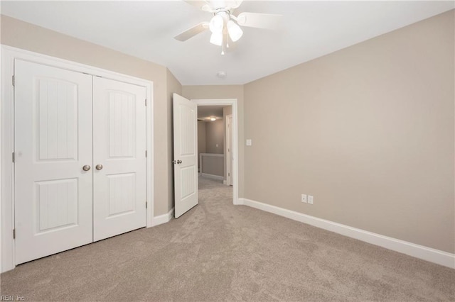 unfurnished bedroom with a closet, baseboards, a ceiling fan, and light colored carpet