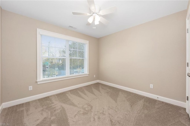 empty room featuring carpet, visible vents, baseboards, and ceiling fan